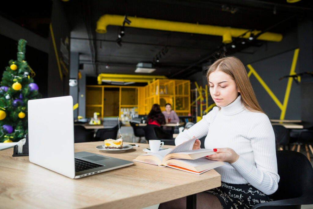 Modern woman working on a laptop at a clean workspace with office desks Edmonton options in a contemporary setting.