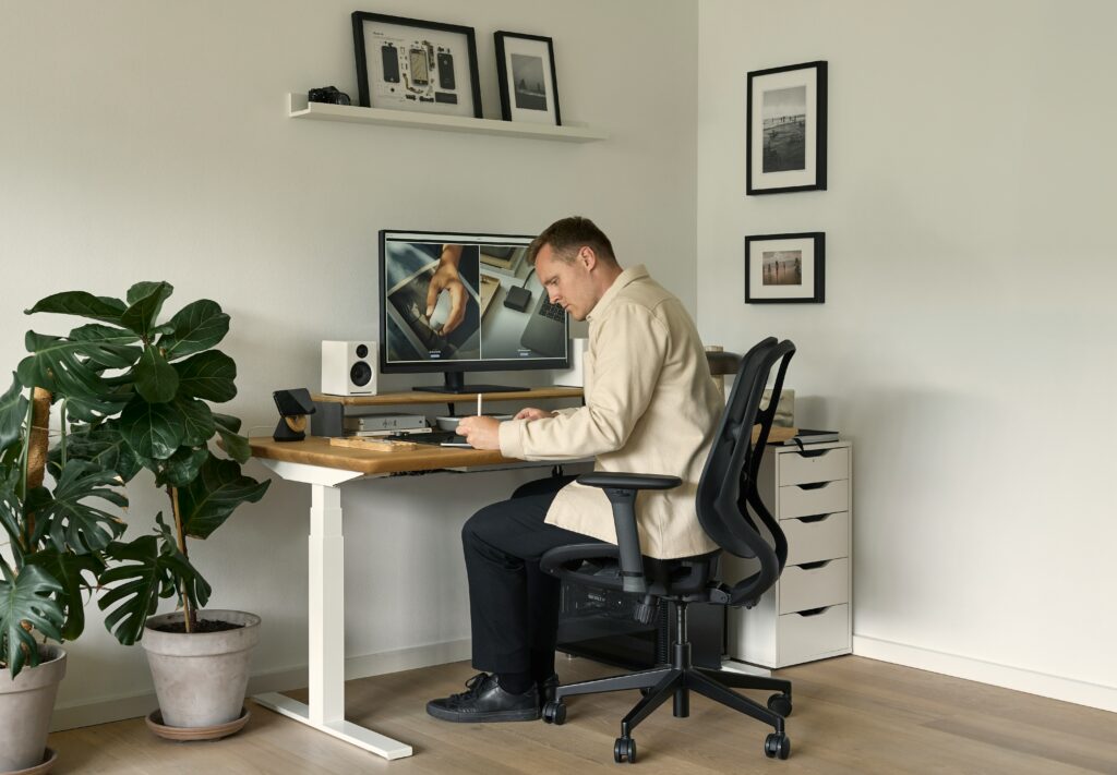 A man is working at a desk on a computer while seated on one of the best office chairs designed for comfort and posture support.