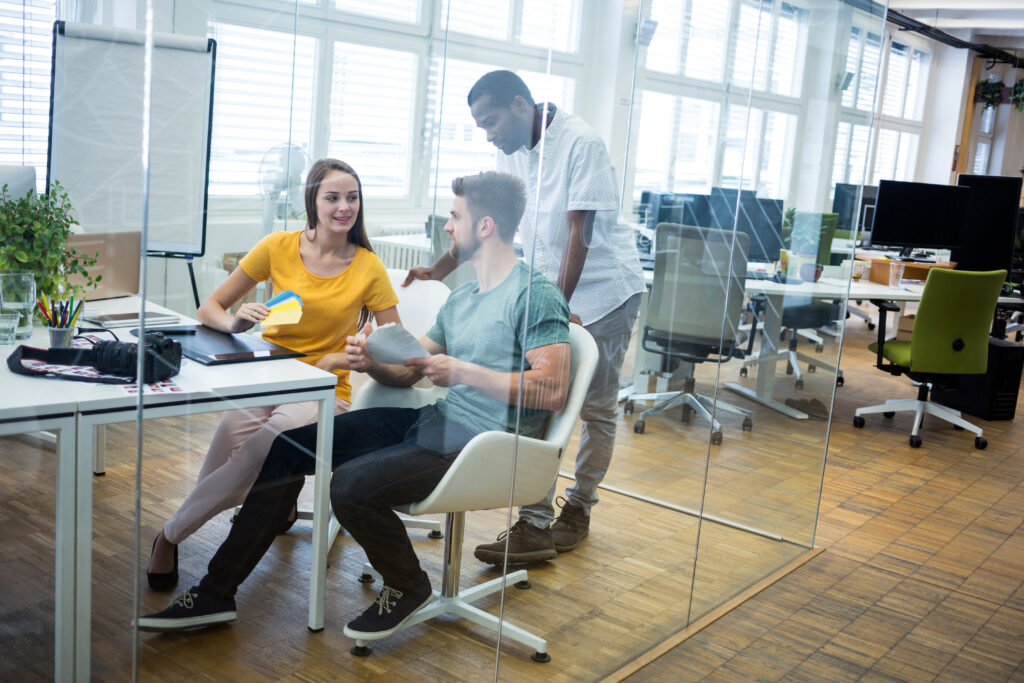Office workers sit on ergonomic office chairs in a modern workplace for comfort and better posture.
