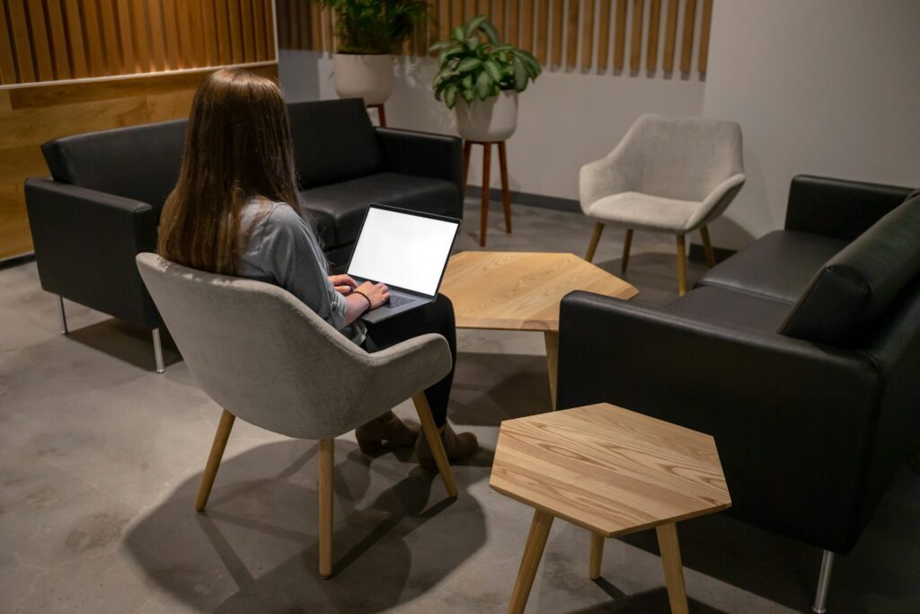 Woman sitting on an ergonomic chair using a laptop showcasing the best office chairs for comfort and productivity.