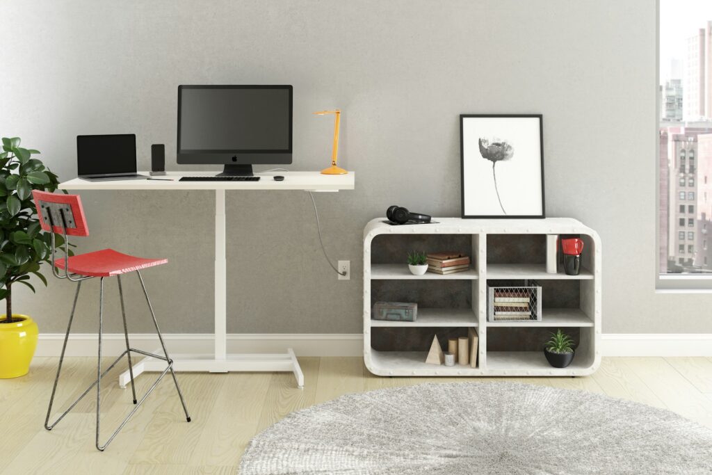 Modern workspace setup with office furniture, including a black flat-screen monitor on a white wooden desk.